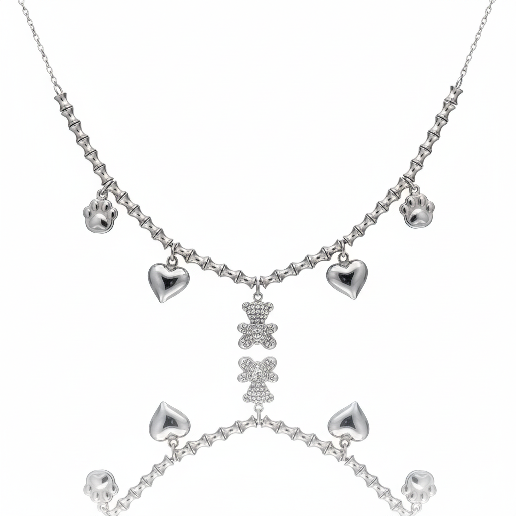 Collana con orsetto sospesa su sfondo bianco specchiato