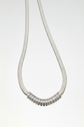 Collana su sfondo bianco specchiato